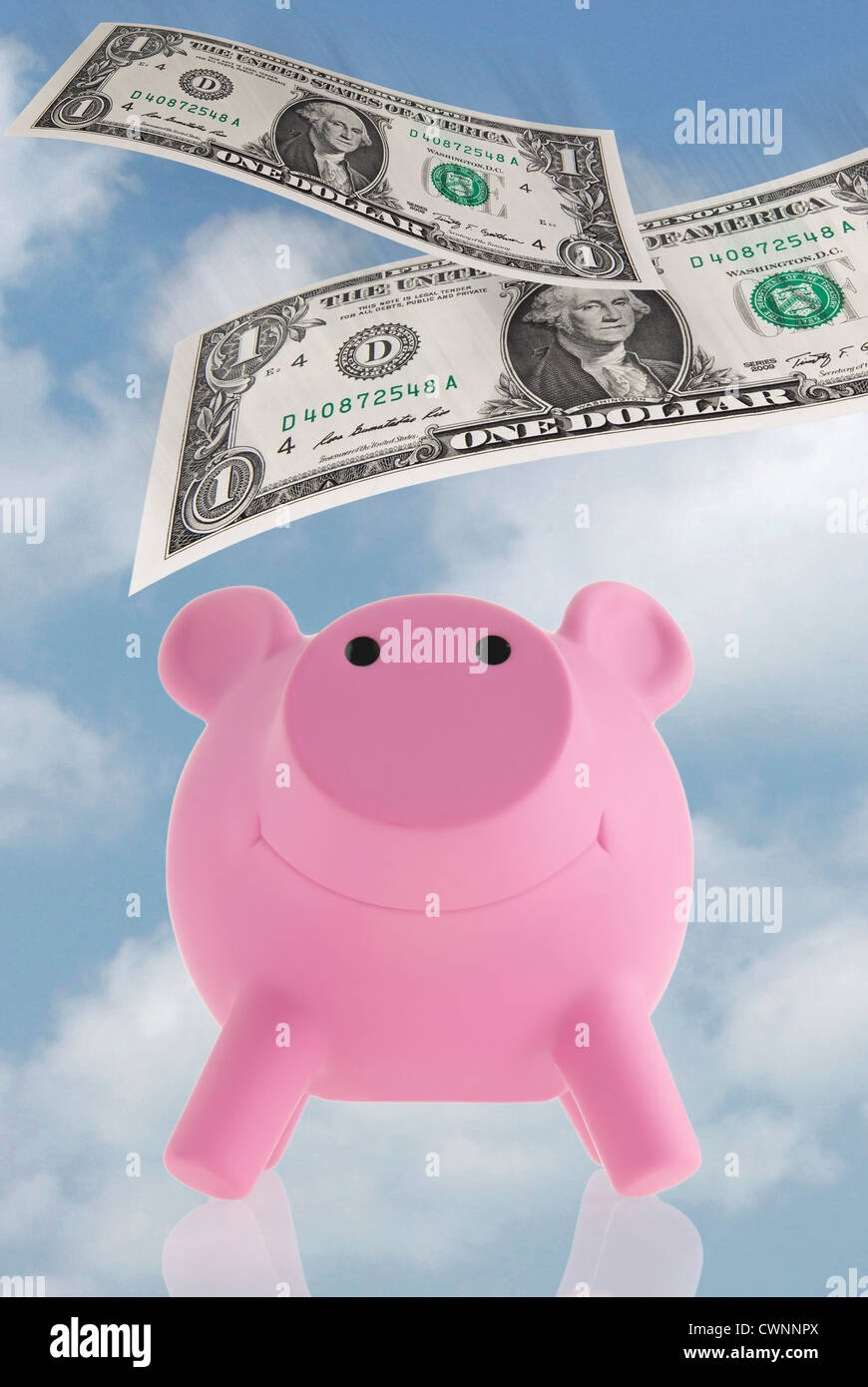 Pink piggy bank with floating banknotes, composing Stock Photo