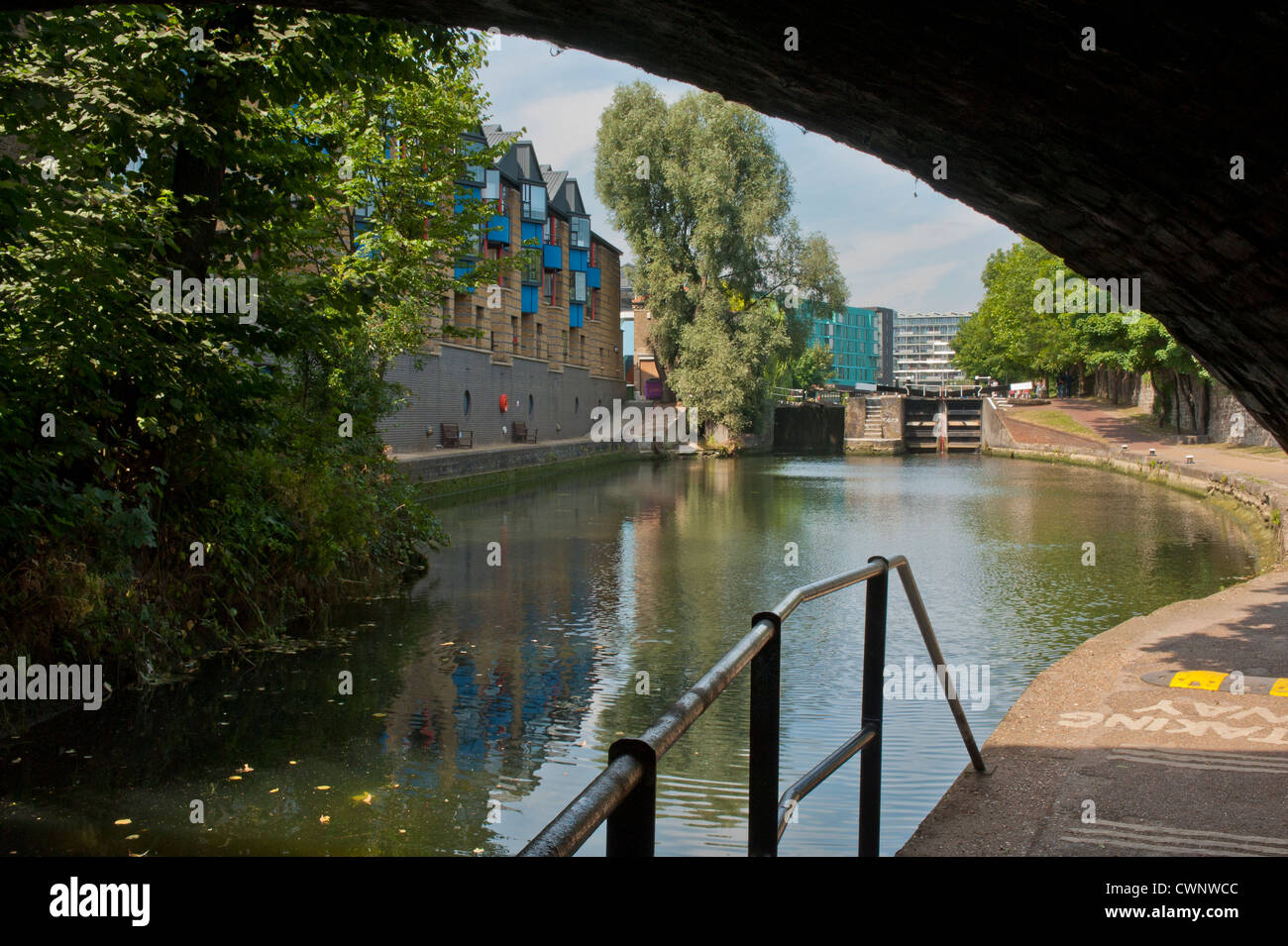 LONDON, UK - AUGUST 11, 2012:  View along Regent's Canal tow path  in Mile End with narrowboats and background of modern apartment buildings Stock Photo