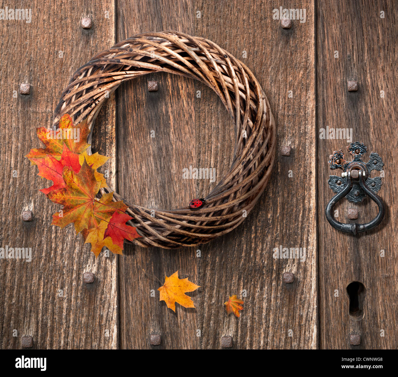 Autumn wreath hanging on heavy Gothic wooden door Stock Photo