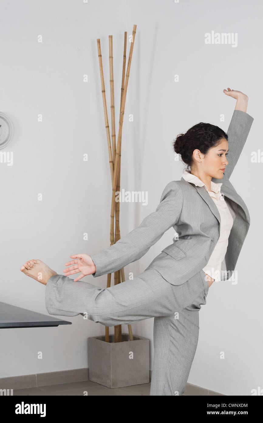 Young businesswoman doing yoga in office Stock Photo - Alamy