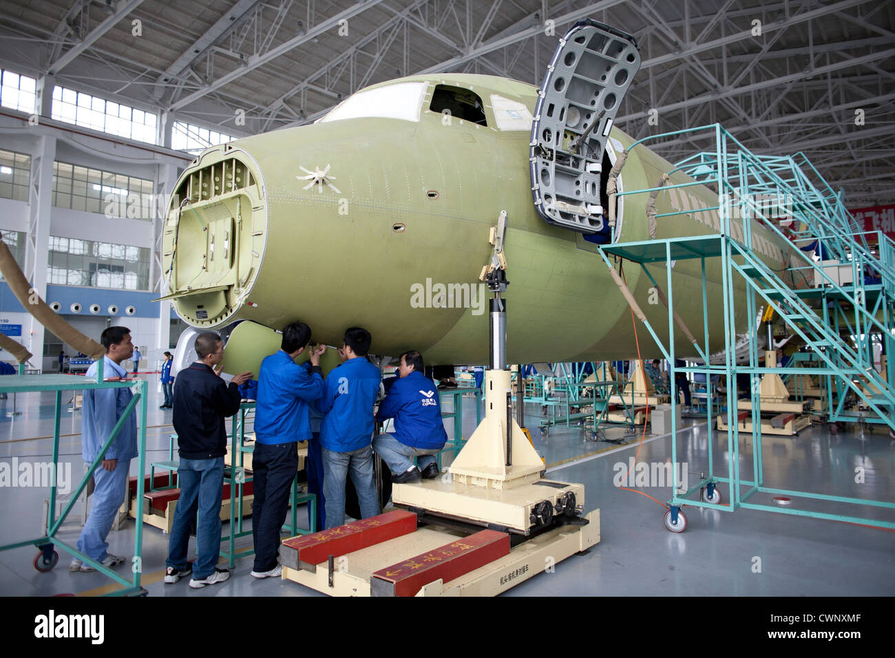 Chinese workers build an ARJ21 passenger plane at a factory of Shanghai Aircraft Manufacturing Company in Shanghai. Stock Photo