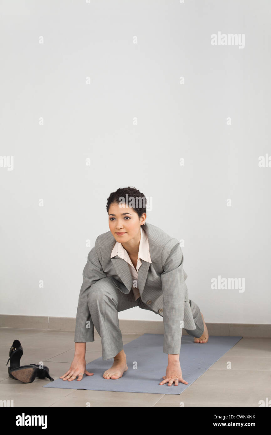 Businesswoman doing yoga in office Stock Photo - Alamy