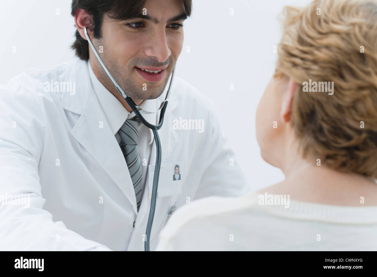 Doctor examining patient using stethoscope Stock Photo - Alamy