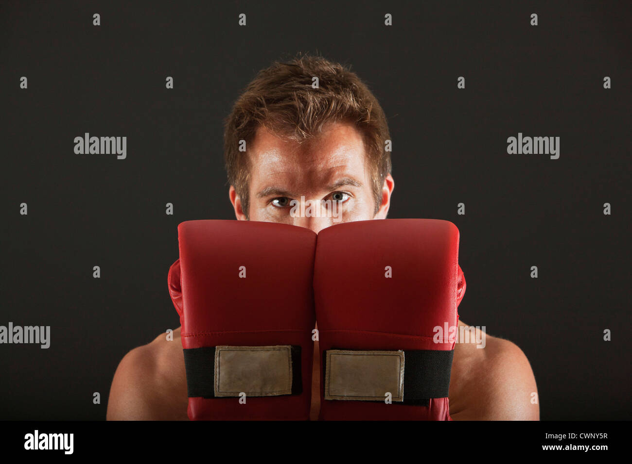Boxer holding up gloves in front of face in defensive position Stock Photo