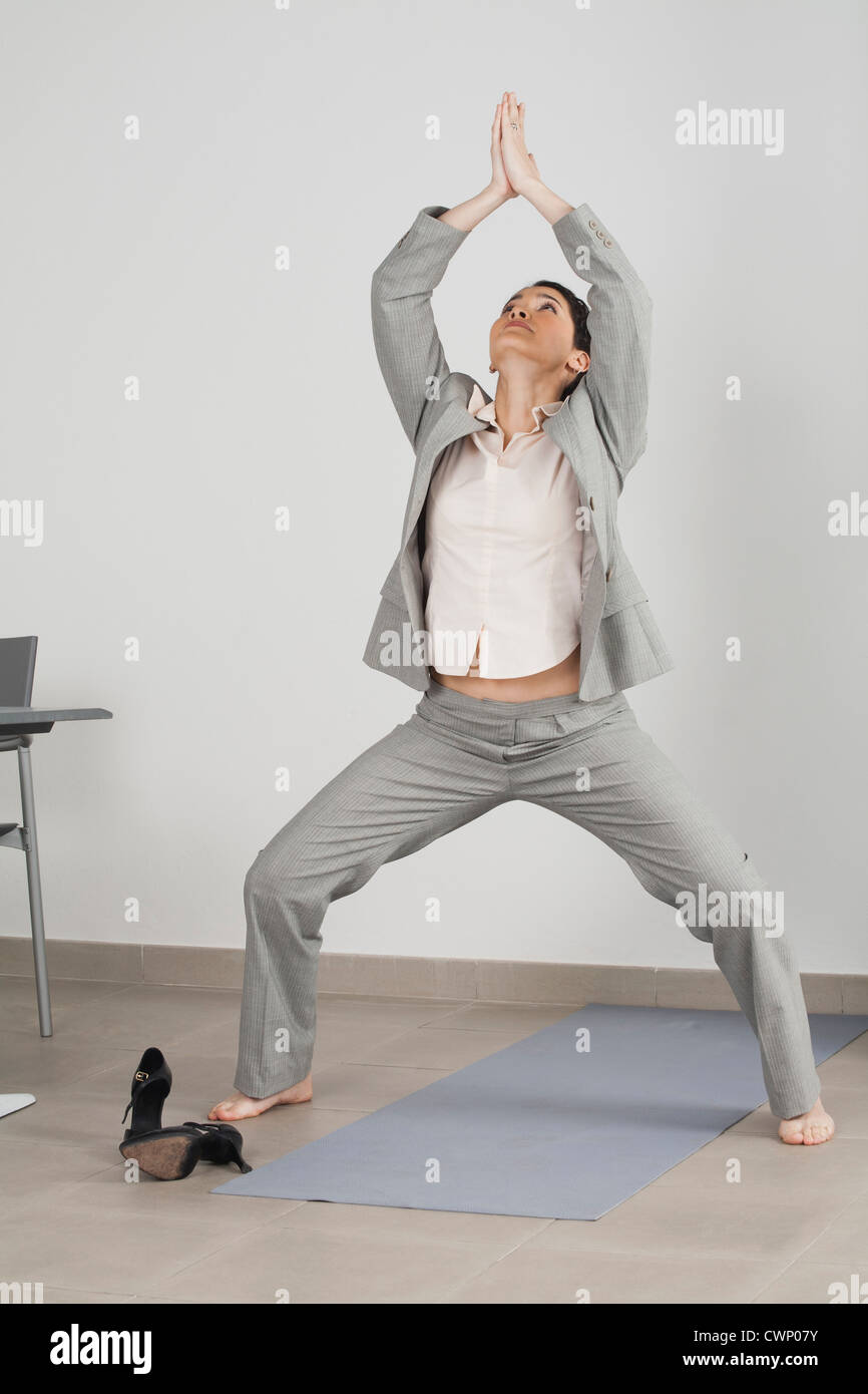 Businesswoman doing yoga in office Stock Photo - Alamy