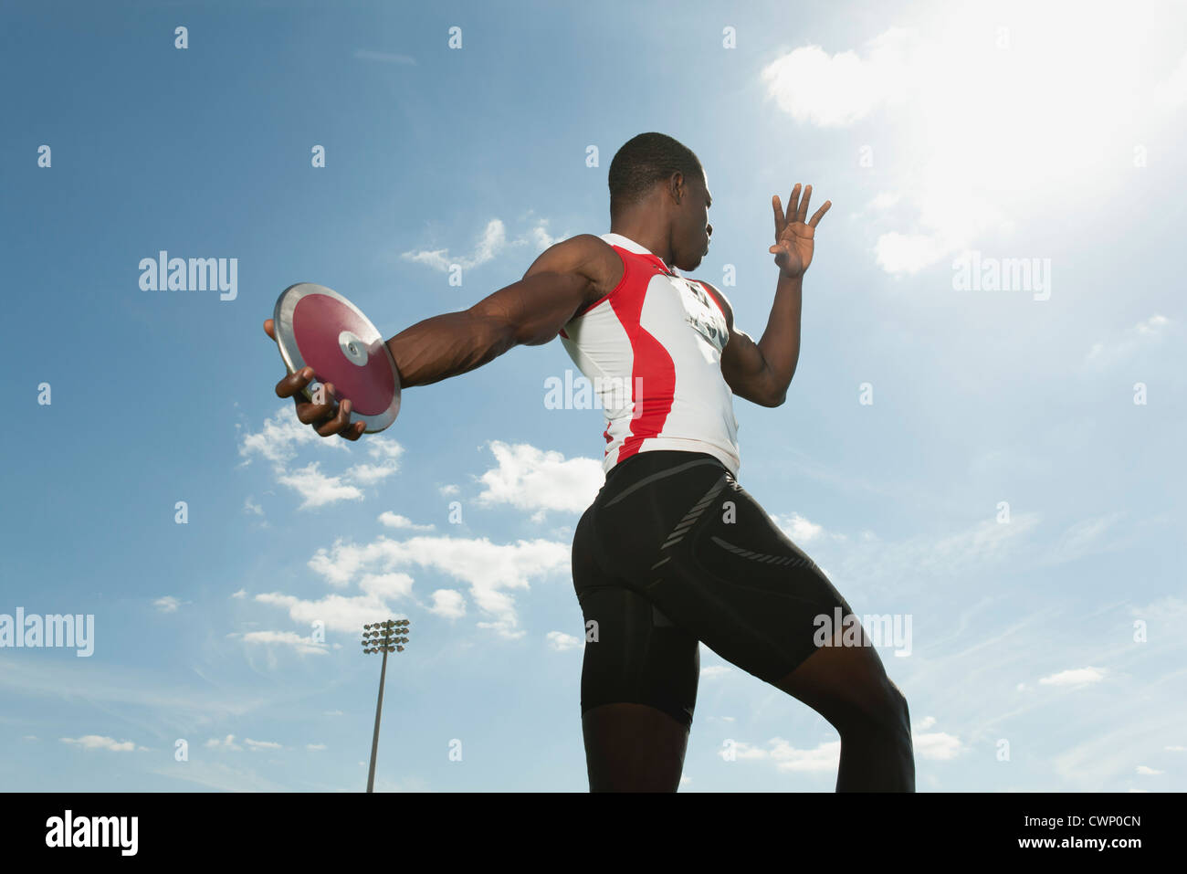 Male athlete throwing discus, low angle view Stock Photo