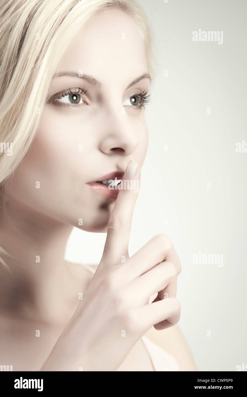 Young woman with finger on lips Stock Photo - Alamy
