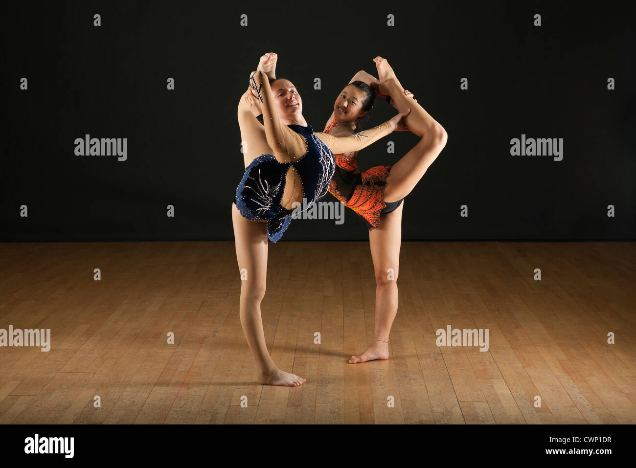 Gymnasts performing standing splits together, portrait Stock Photo