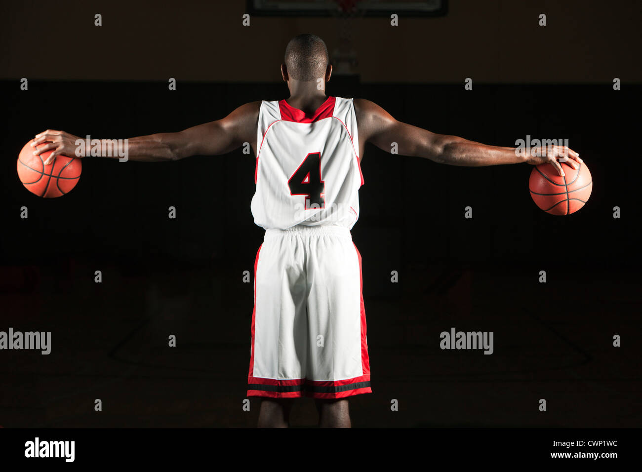 Basketball player holding two basketballs, rear view Stock Photo Alamy