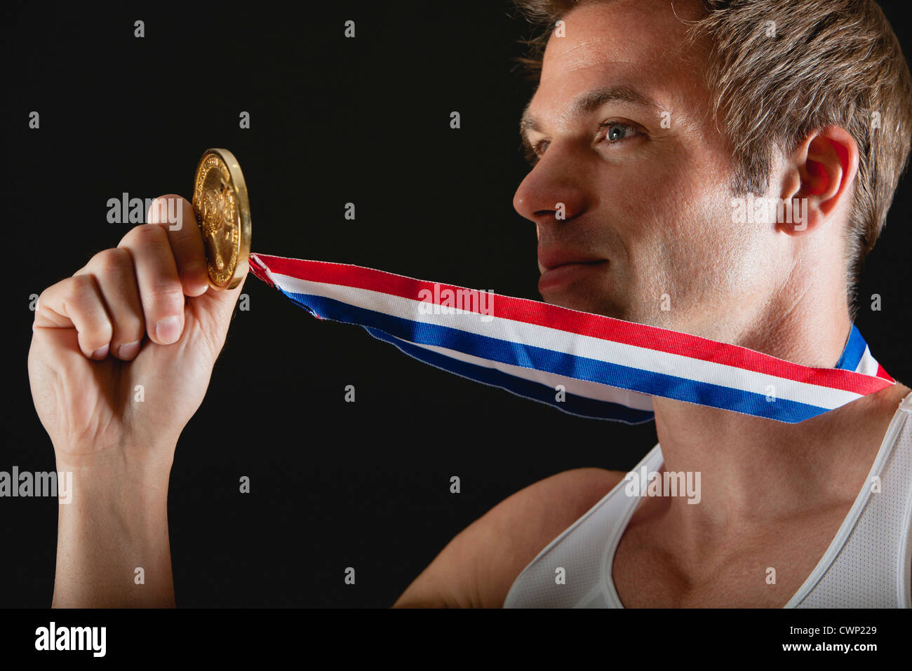 Athlete holding gold medal Stock Photo