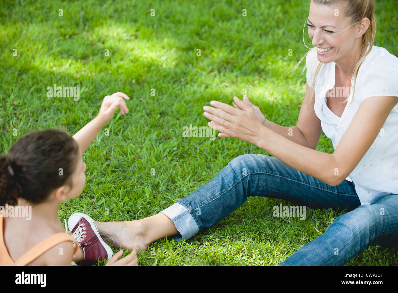Mother and daughter playing on grass Stock Photo