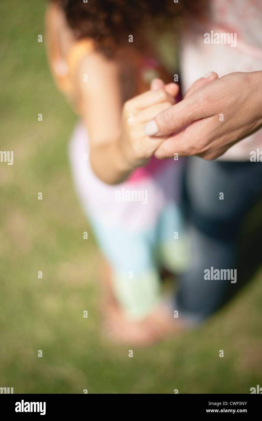 Mother and daughter holding hands, cropped Stock Photo