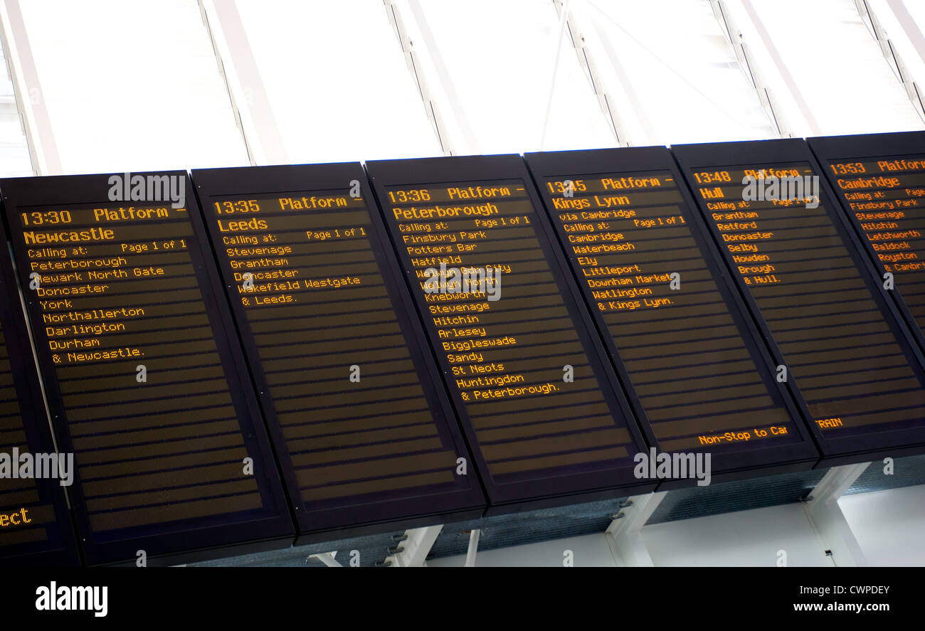 Seen from below a railway departure board with various British place names, times and platform details on it. Stock Photo