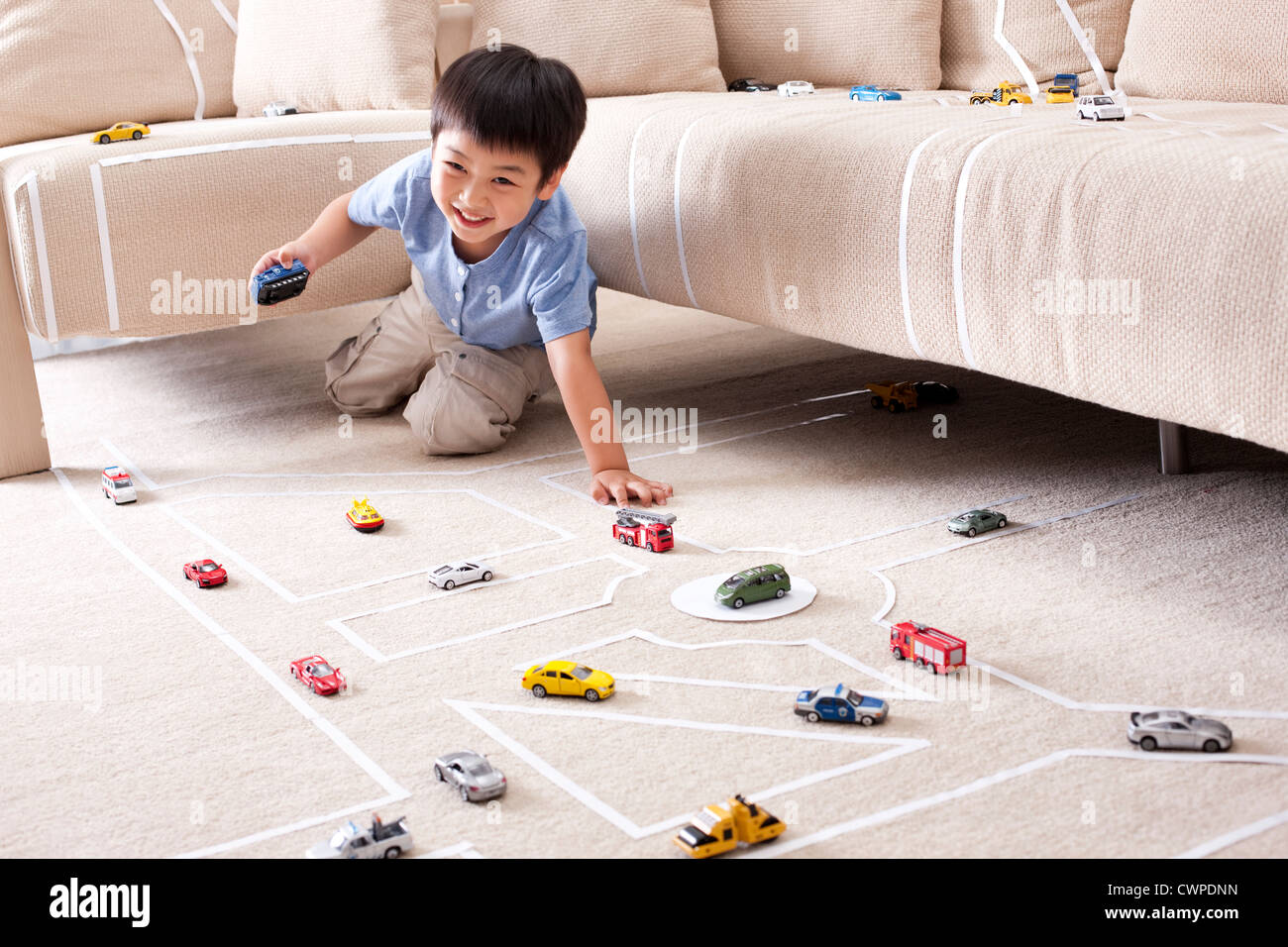 Boy playing toy car at home Stock Photo - Alamy