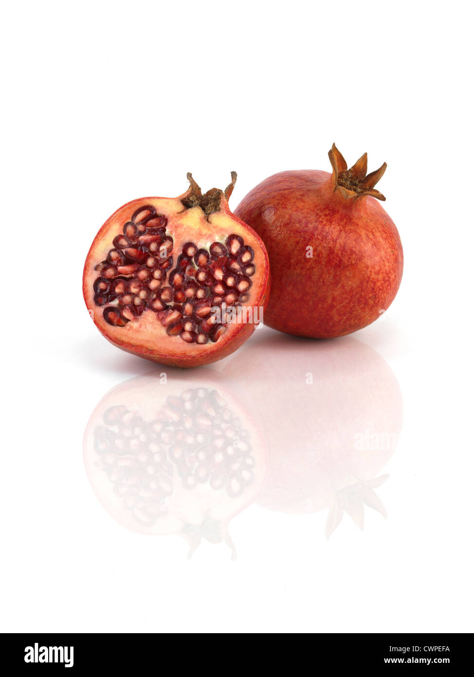 pomegranates on reflective white background Stock Photo