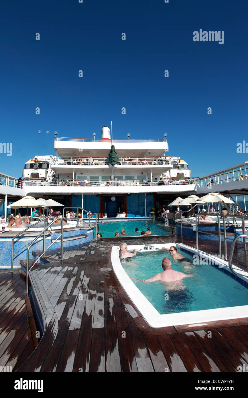 Holiday makers relaxing on deck on a cruise ship in the sunshine. Stock Photo