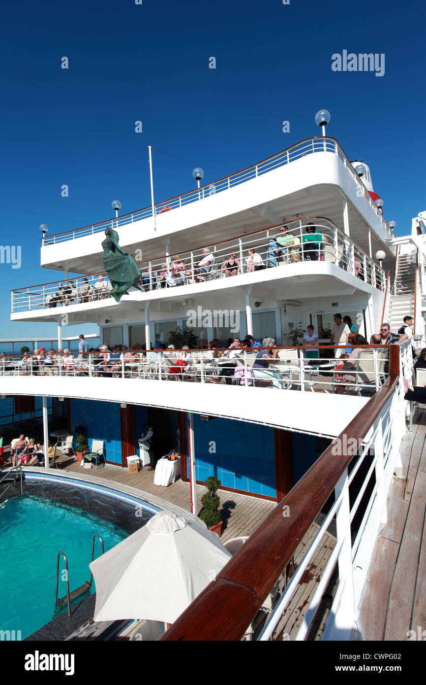Holiday makers relaxing on deck on a cruise ship in the sunshine. Stock Photo