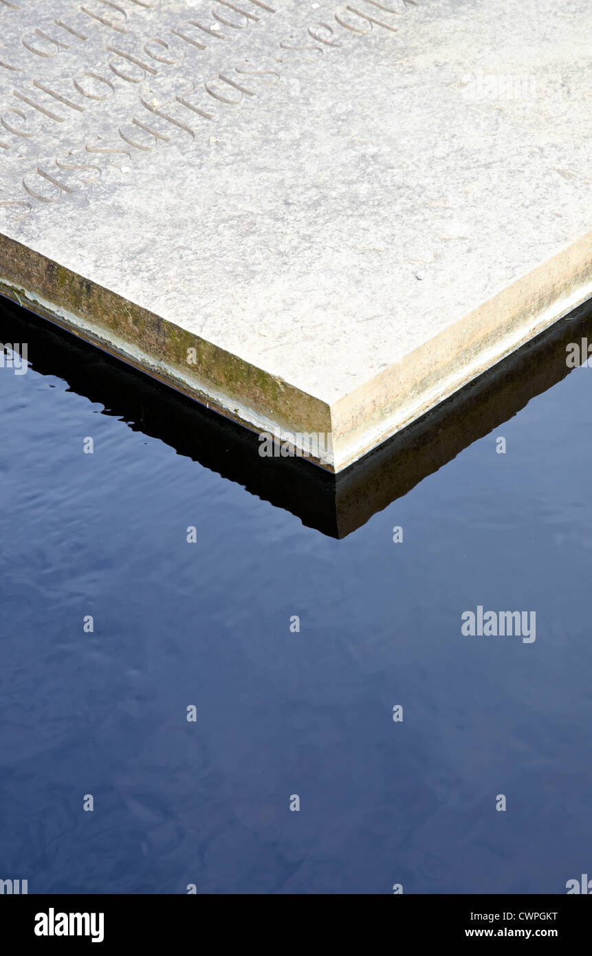 Stone plinth with carved inscription surrounded by dark water Stock ...