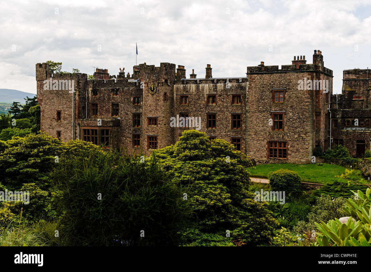 With its dark weathered crenelated stone walls, turrets and towers, Muncaster Castle typifies an old English border stronghold Stock Photo