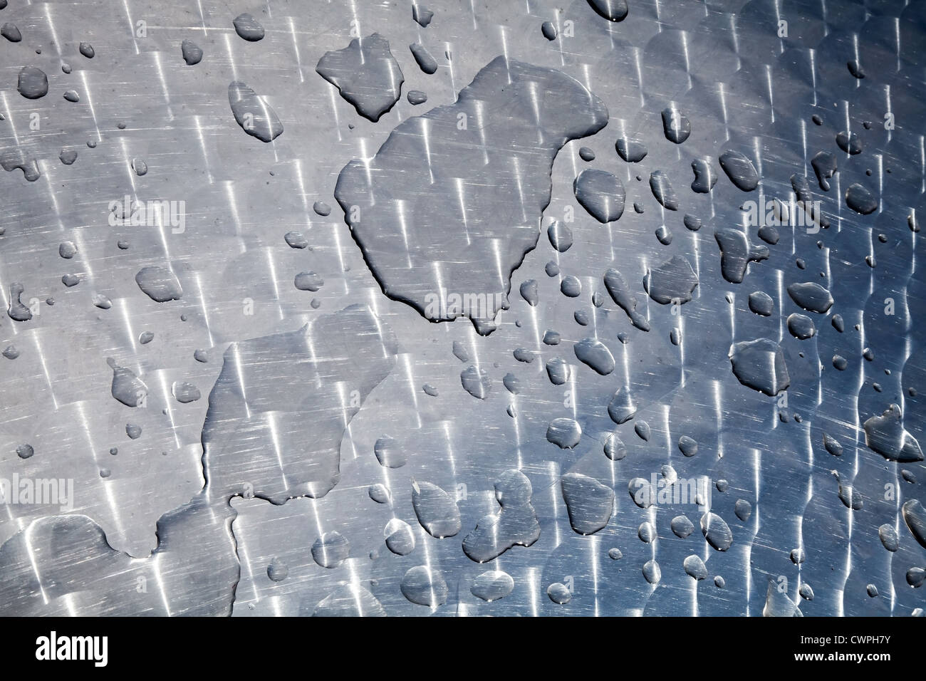 Texture of water drops on shining metal table surface with scratches and circular milling Stock Photo