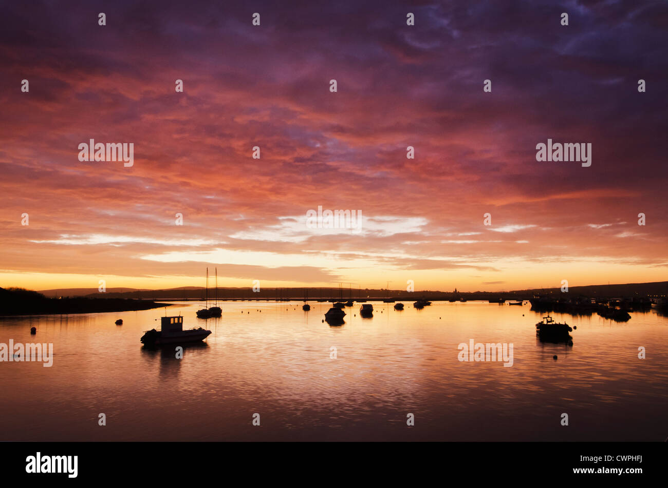 View before dawn towards the Isle of Wight with boats moored on the sea and a colourful sky Stock Photo