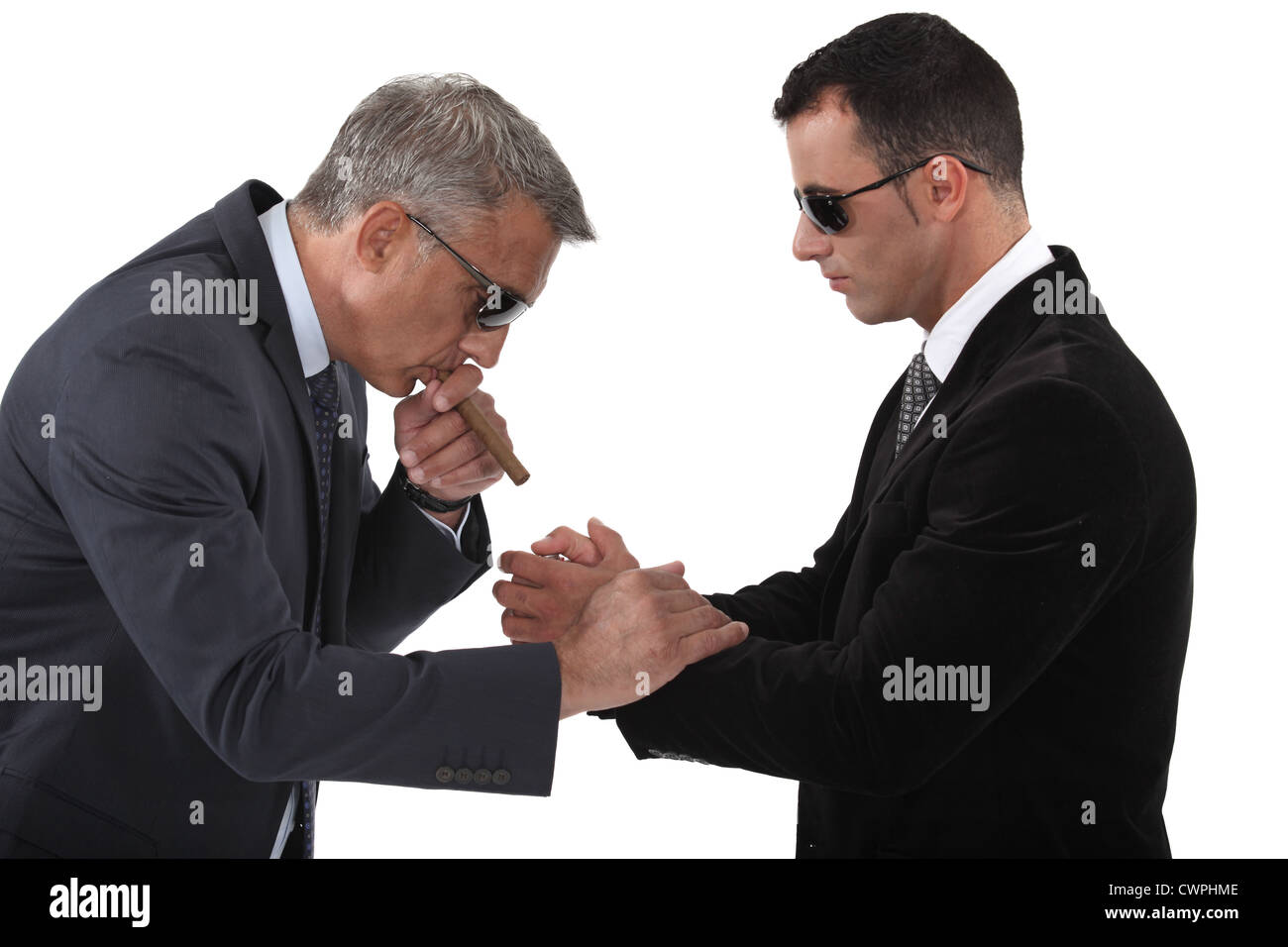 Mobster helping his boss light a cigar Stock Photo