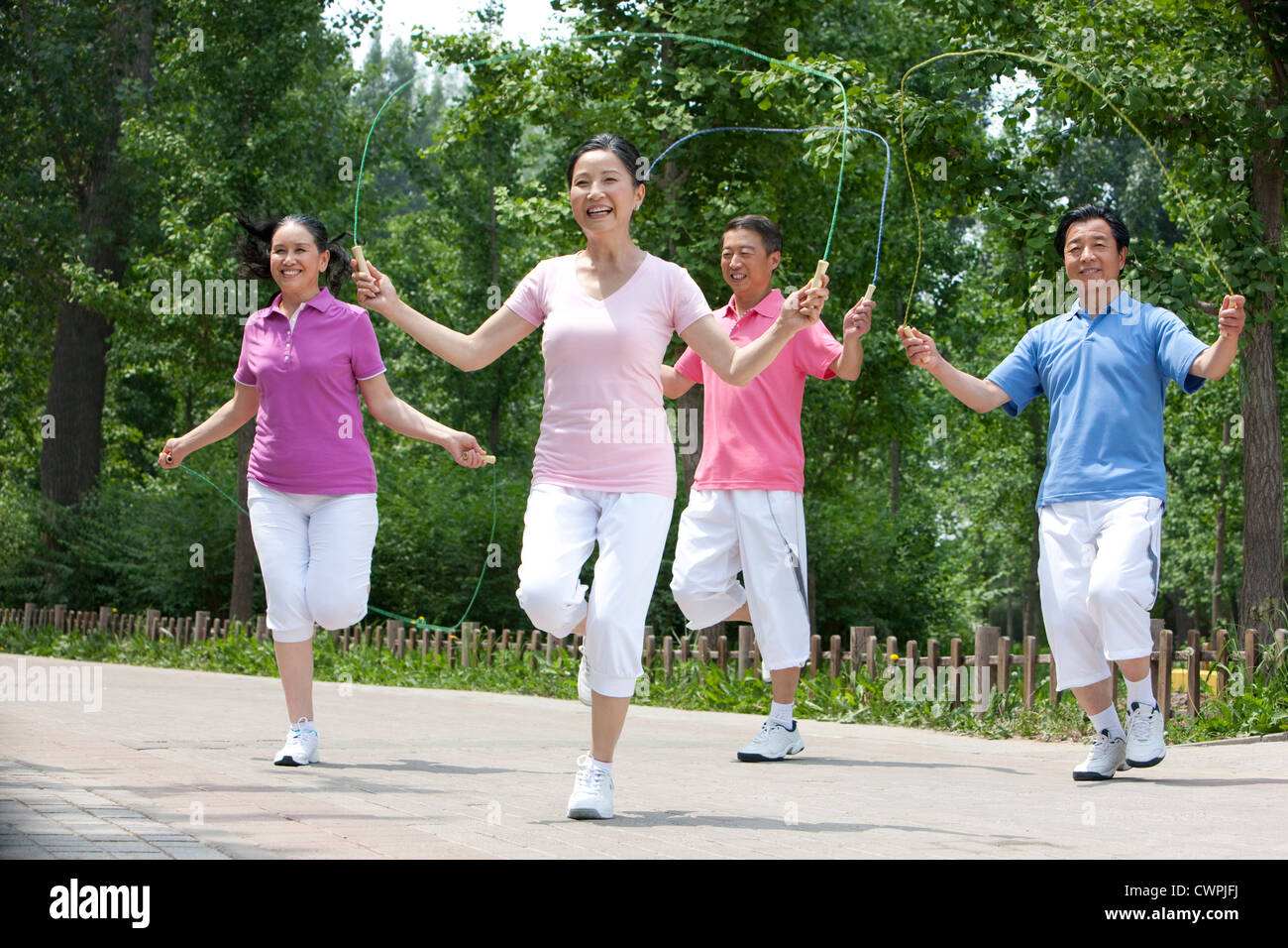 Seniors playing jumping rope in park Stock Photo Alamy
