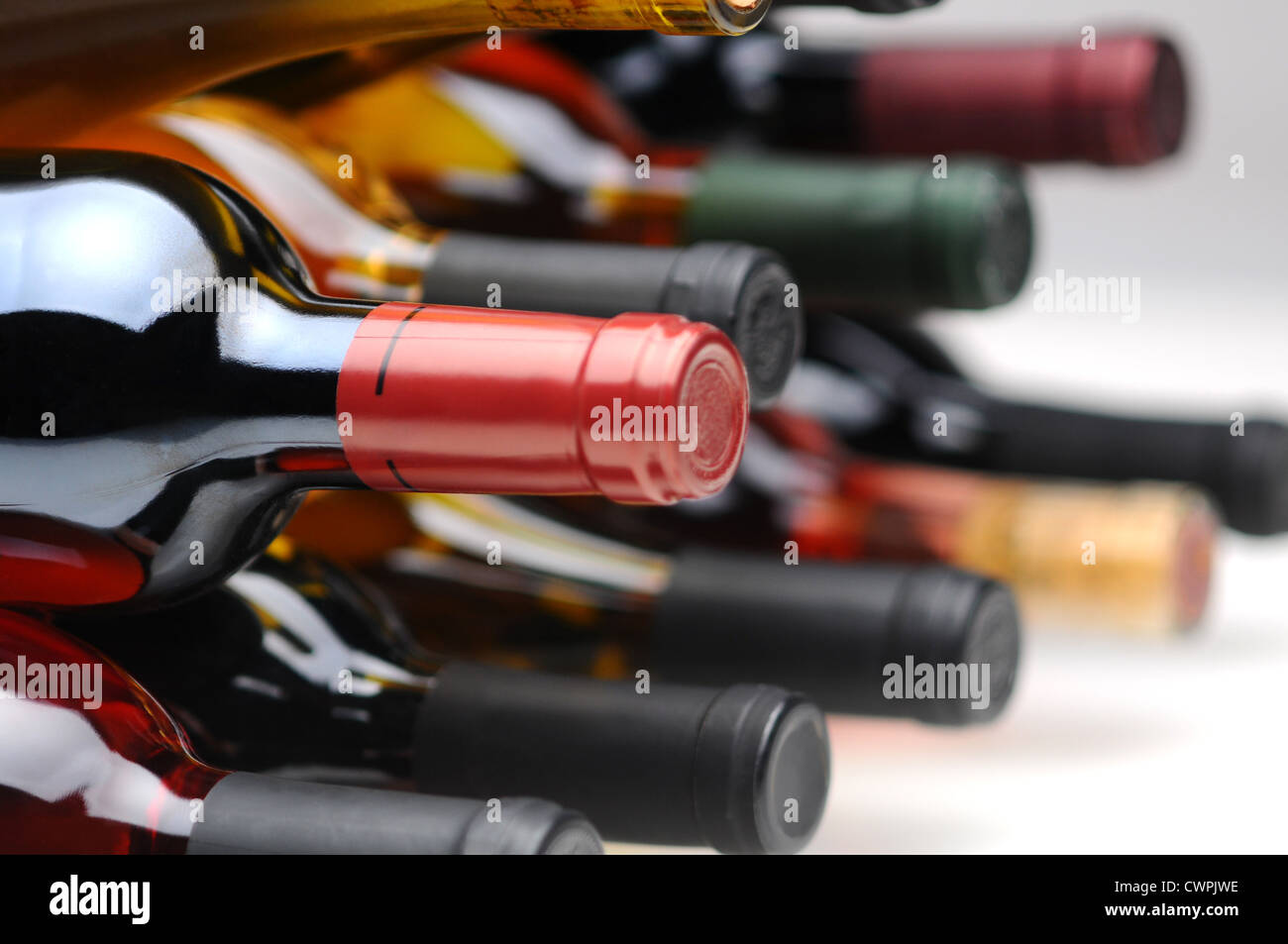 Closeup of several assorted wine bottles laying on their side