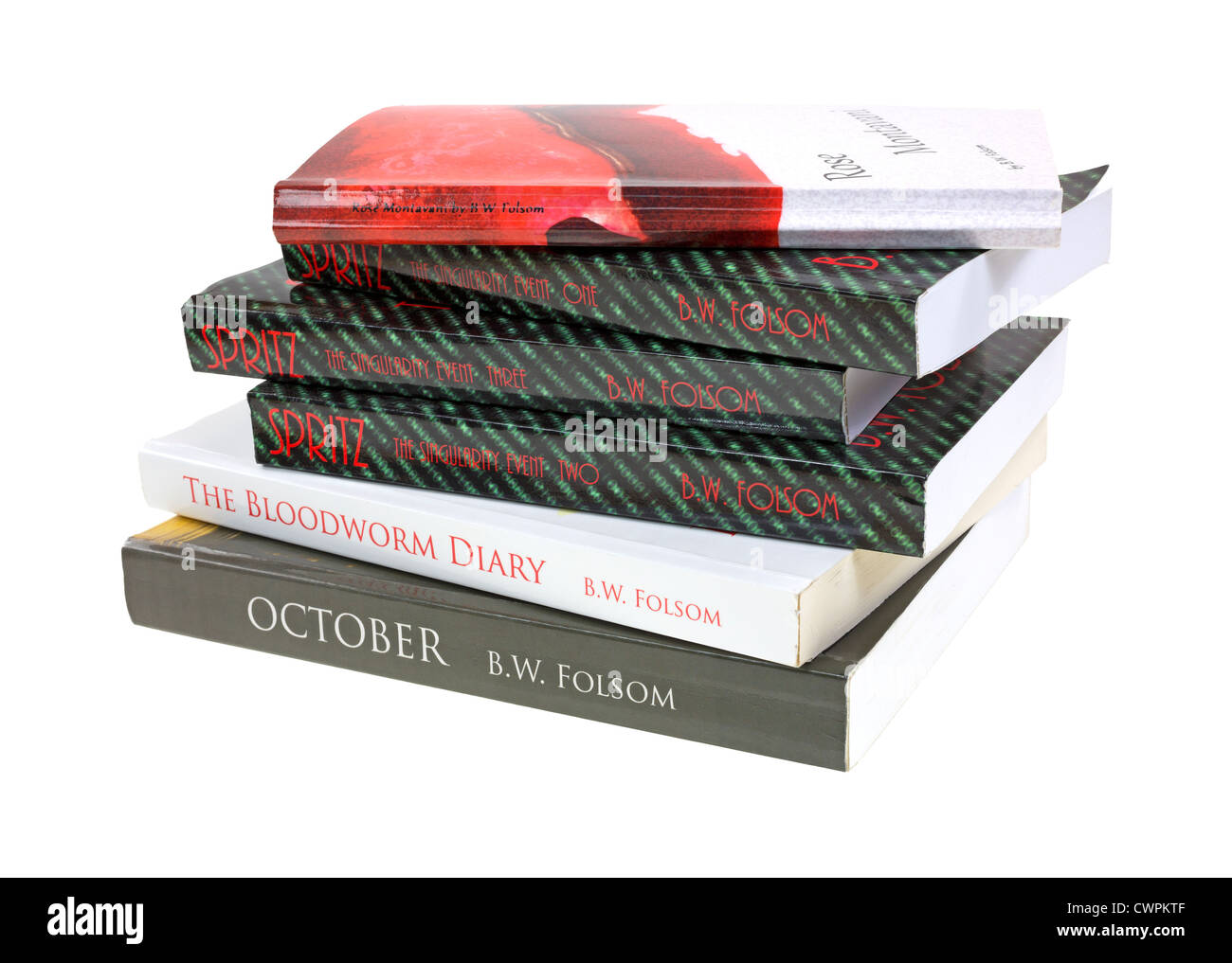 Several soft cover books sloppily stacked on a white background. Stock Photo