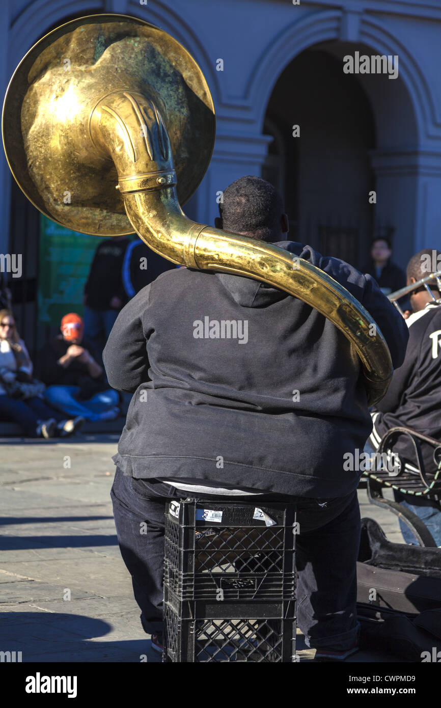 Street performer sitting playing jazz on a tuba in the historic French