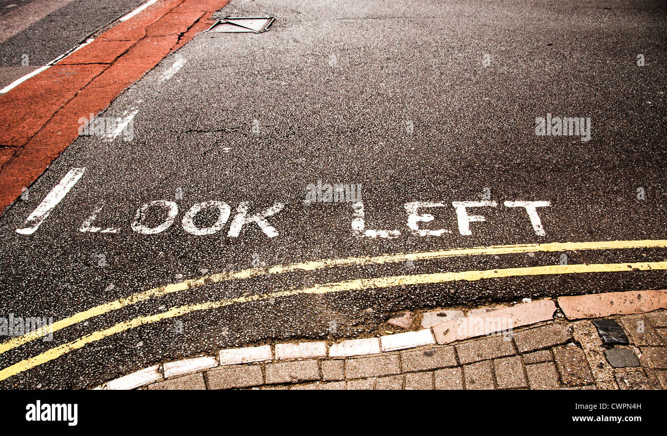 Road marking warning to Look left before crossing the road Stock Photo