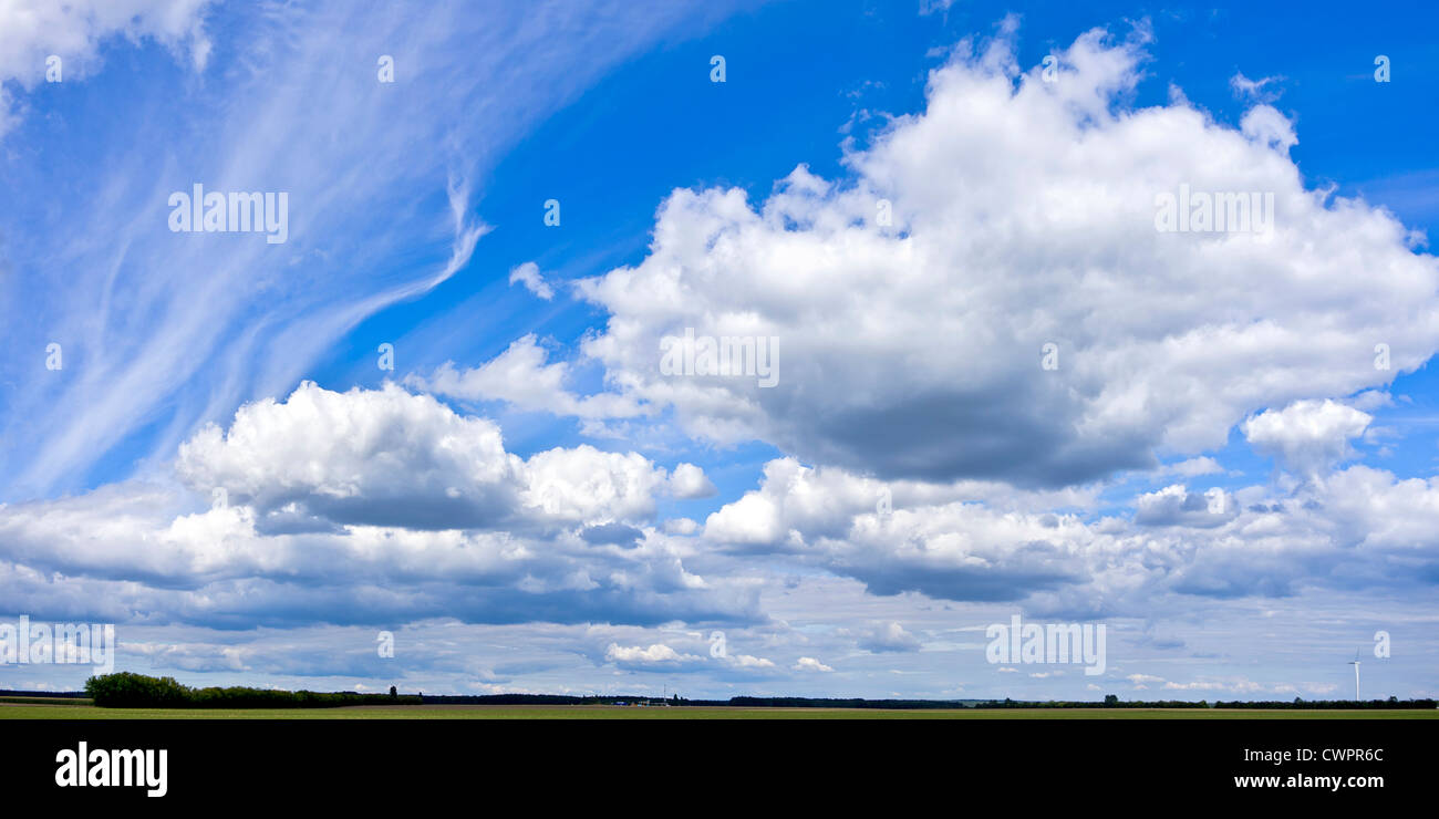 Plain country and formation of big clouds on a blue summer sky. Stock Photo