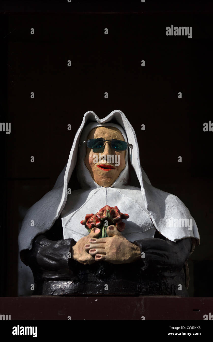 Comical mannequin of nun with sunglasses at restaurant window, Begijnhof, Bruges, Belgium Stock Photo