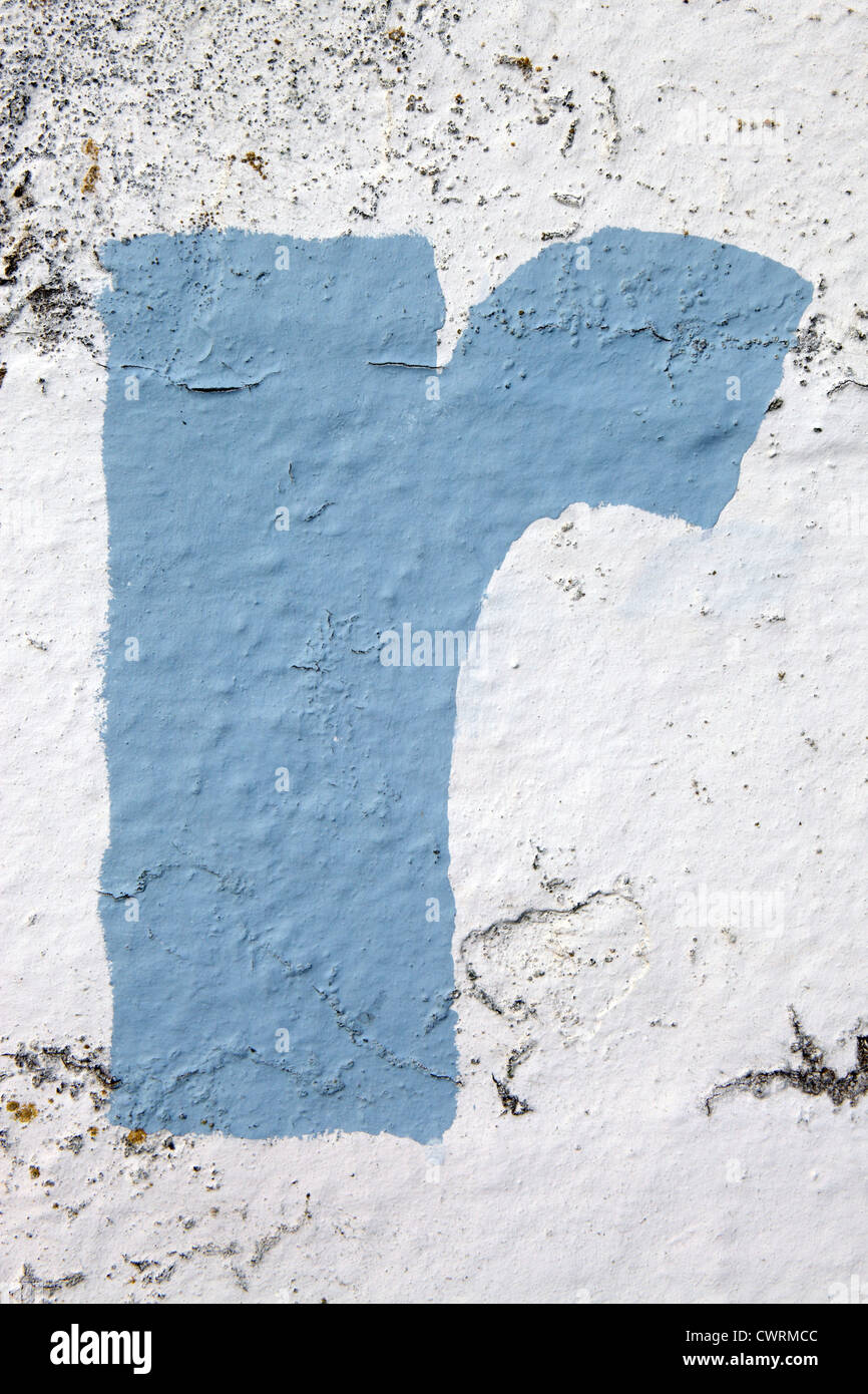Lower case letter 'r' in sky blue paint stenciled onto crumbling exterior wall, UK. For other letters see Nick Sinclair folio Stock Photo