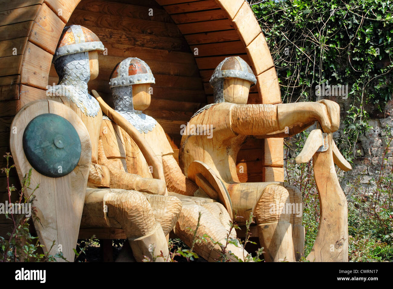 A carving of faceless, seated Norman soldiers on a roadside in Rhuddlan, North Wales. Stock Photo