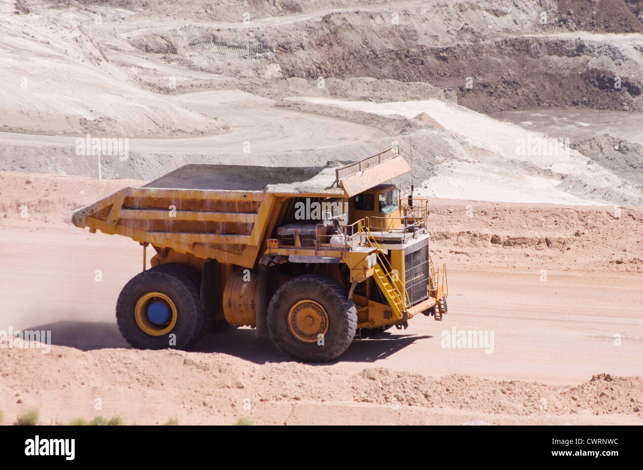 large yellow haul or dump truck driving at an open pit mine Stock Photo
