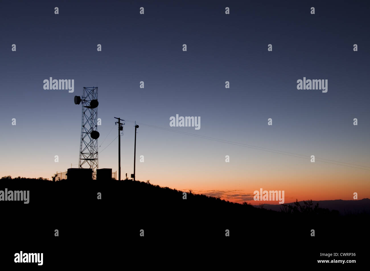 silhouette of a microwave antenna tower against an evening sky Stock Photo