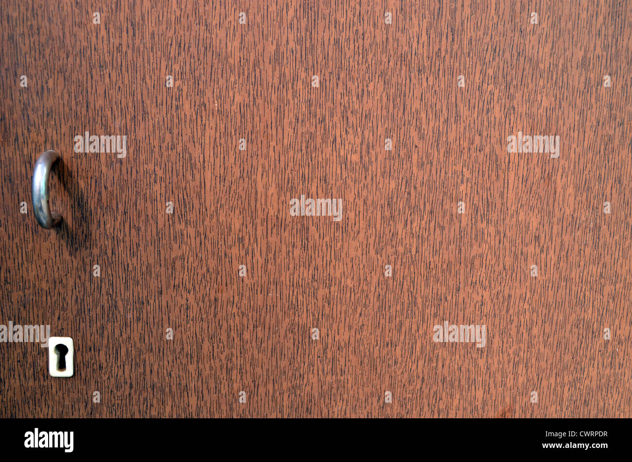 Retro wooden brown cupboard key hole and door handle background. Stock Photo