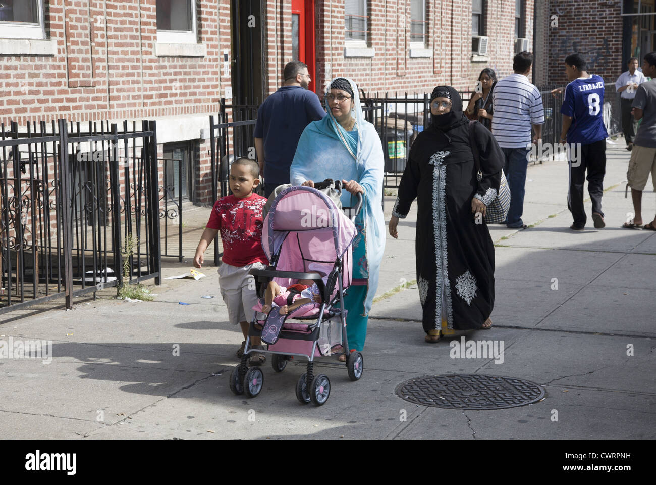 Bangladeshi Muslim women walk on McDonald Avenue in Little Bangladesh, a section of the Kensington section of Brooklyn, NY. Stock Photo