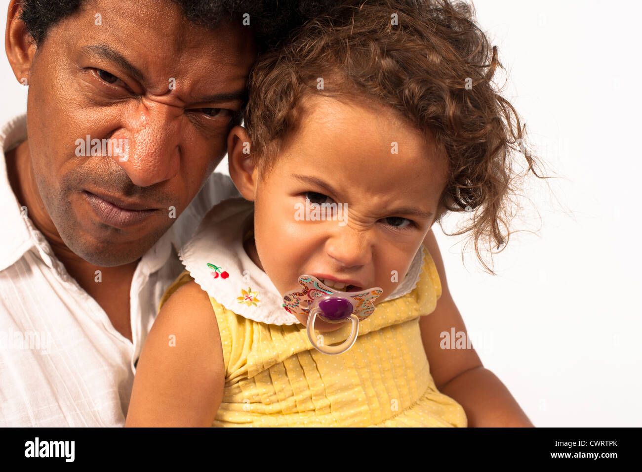 African Amercian dad and his daughter giving the camera an angry look Stock Photo