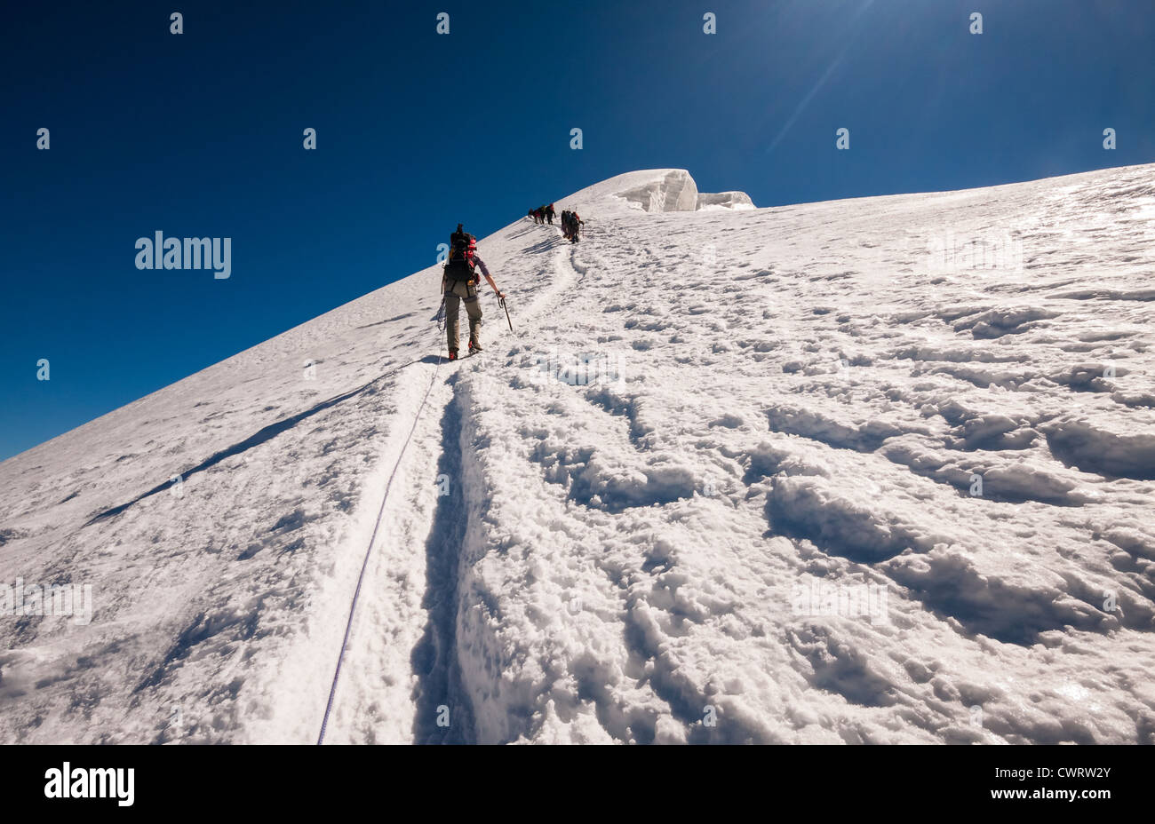 Climbers ascend the final steep section of snow that leads to the summit of Weissmies. Saas Grund Switzerland. Stock Photo