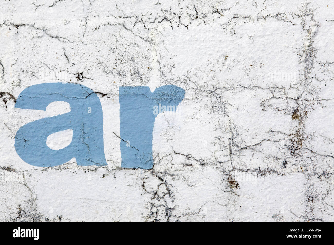 Lettering 'ar', stencil style sky blue paint on a white washed wall background, crumbling and distressed look, Cornwall, UK Stock Photo