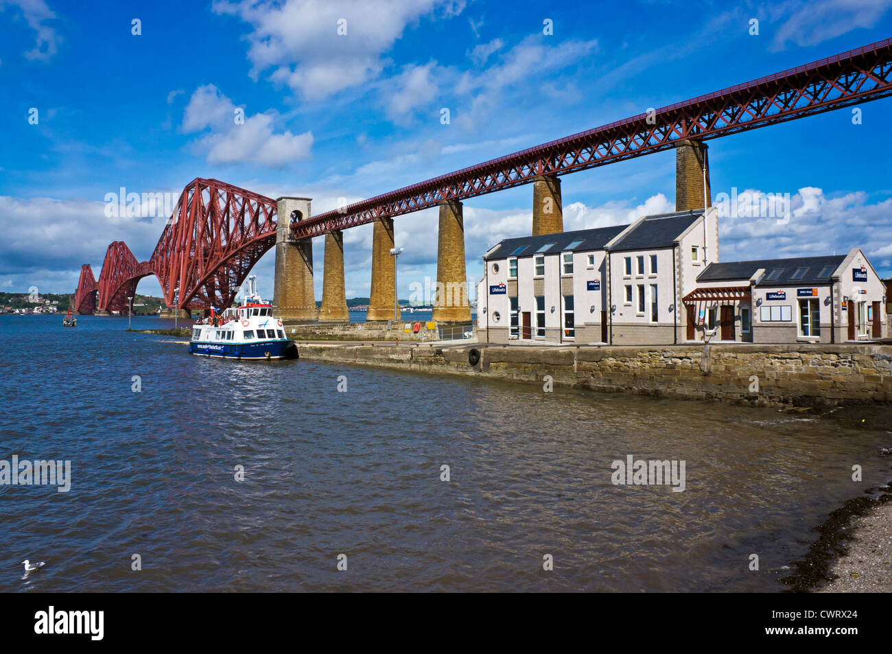 The iconic Forth Rail bridge and pier with buildings and Maid of the Forth at South Queensferry Scotland Stock Photo