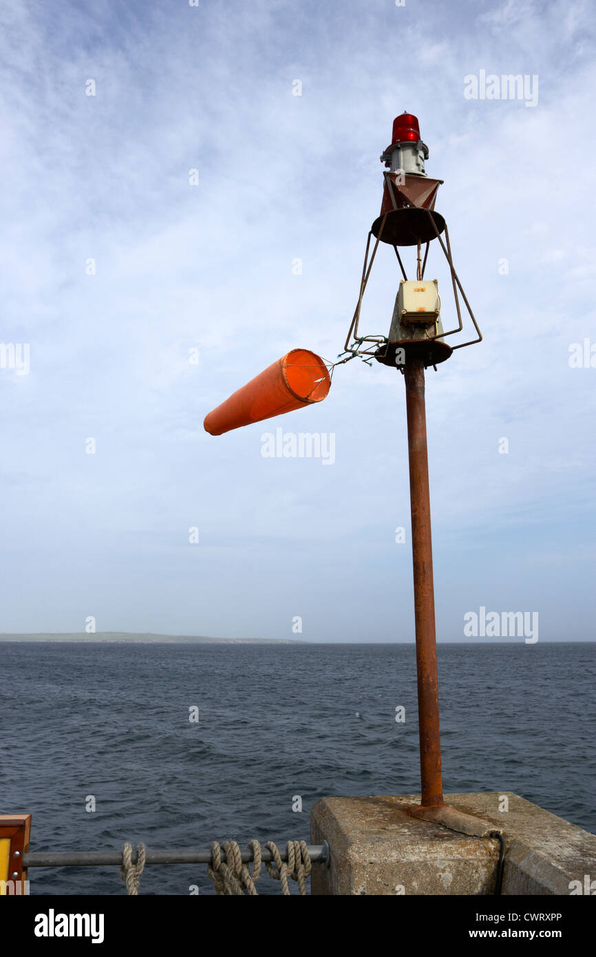 windsock flying on a harbour light mast in high winds John O'Groats scotland uk Stock Photo