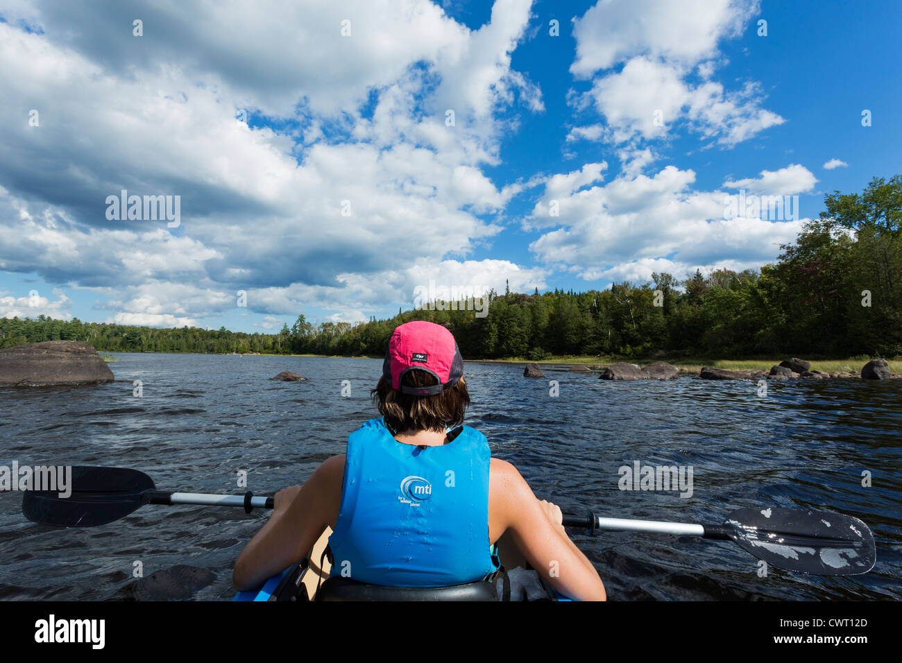 Young female wearing life jacket enjoying a kayaking on the in the