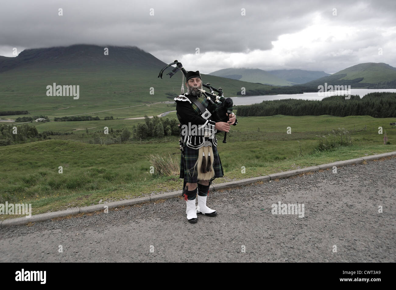 Bagpipe player playing in the highlands Stock Photo