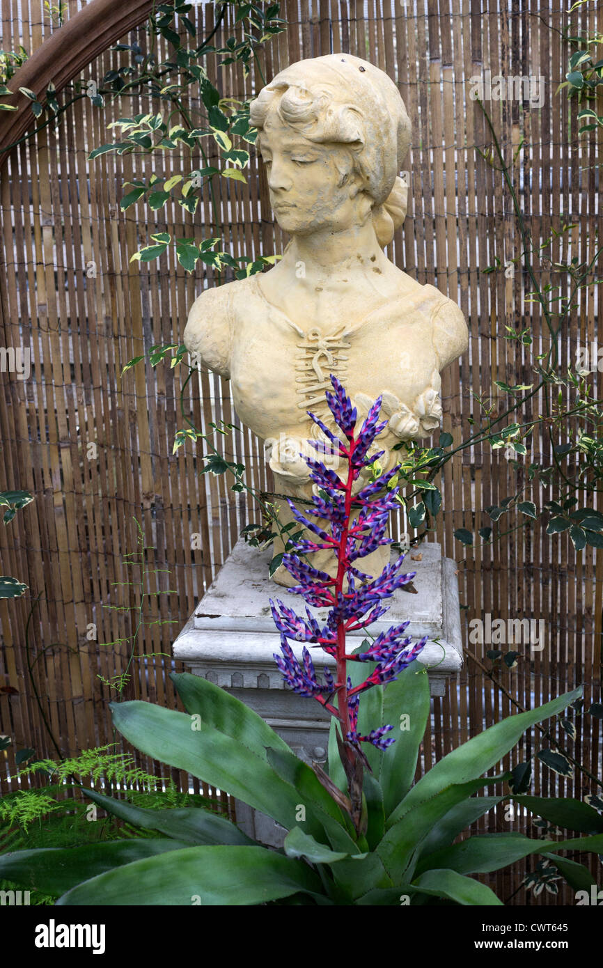 Statue with brightly coloured flowers Stock Photo