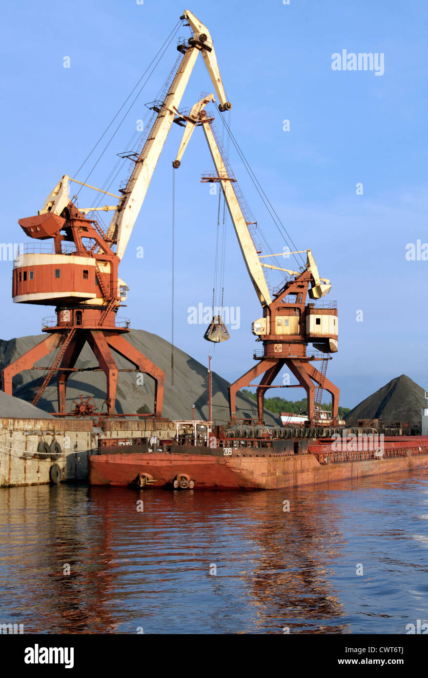 Two dock clamshell crane and barge Stock Photo
