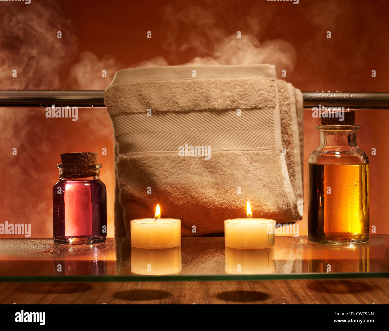 Candles and bath oils steamy bathroom and towel rail Stock Photo