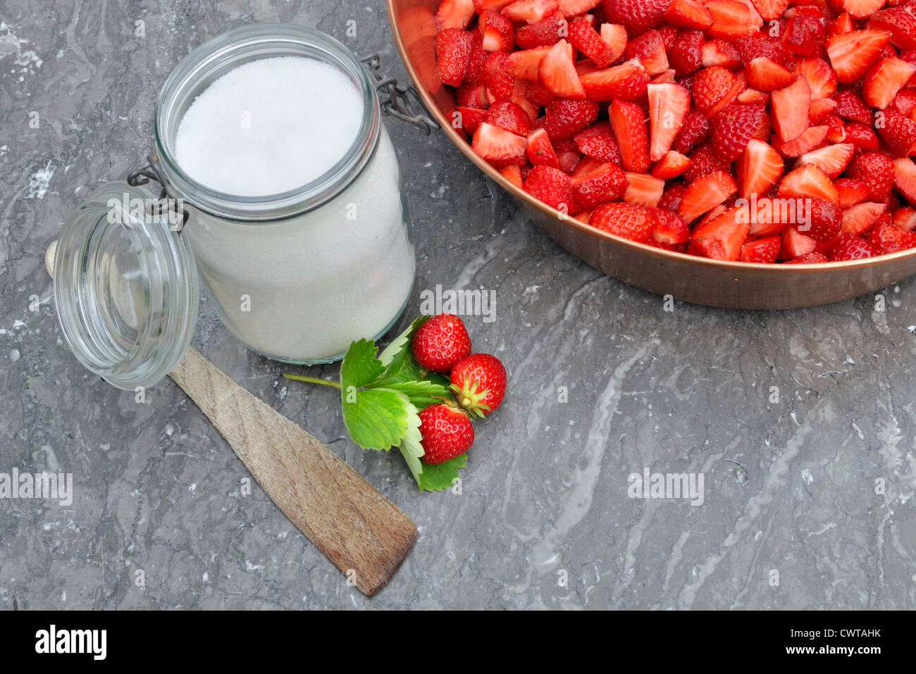 Strawberries in jam manufacturer i with sugar and jars for making jam Stock Photo